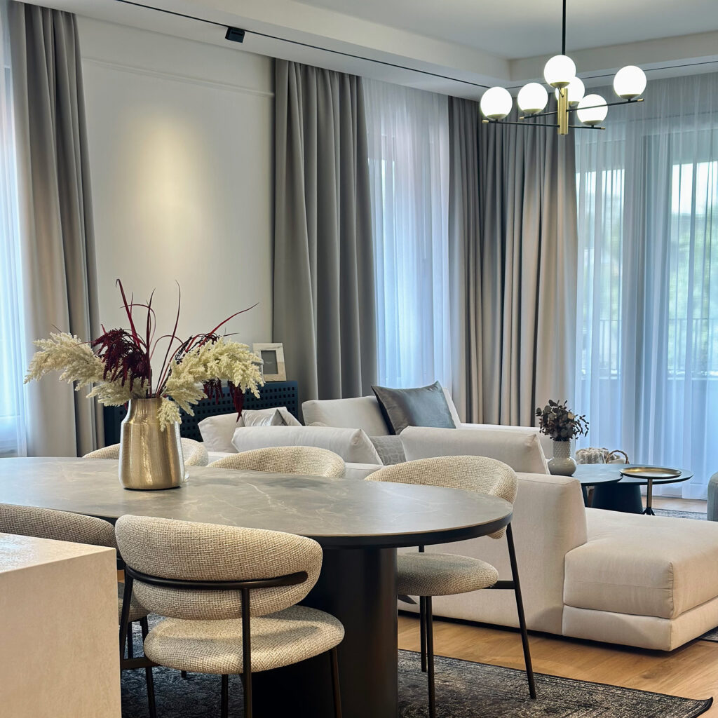 Elegantno usklađen dnevni boravak i trpezarija gdje neutralne nijanse, meke teksture i prirodno svjetlo stvaraju savršenu harmoniju modernog doma.